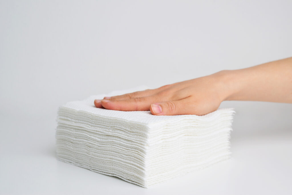 A hand on top of a stack of paper towels