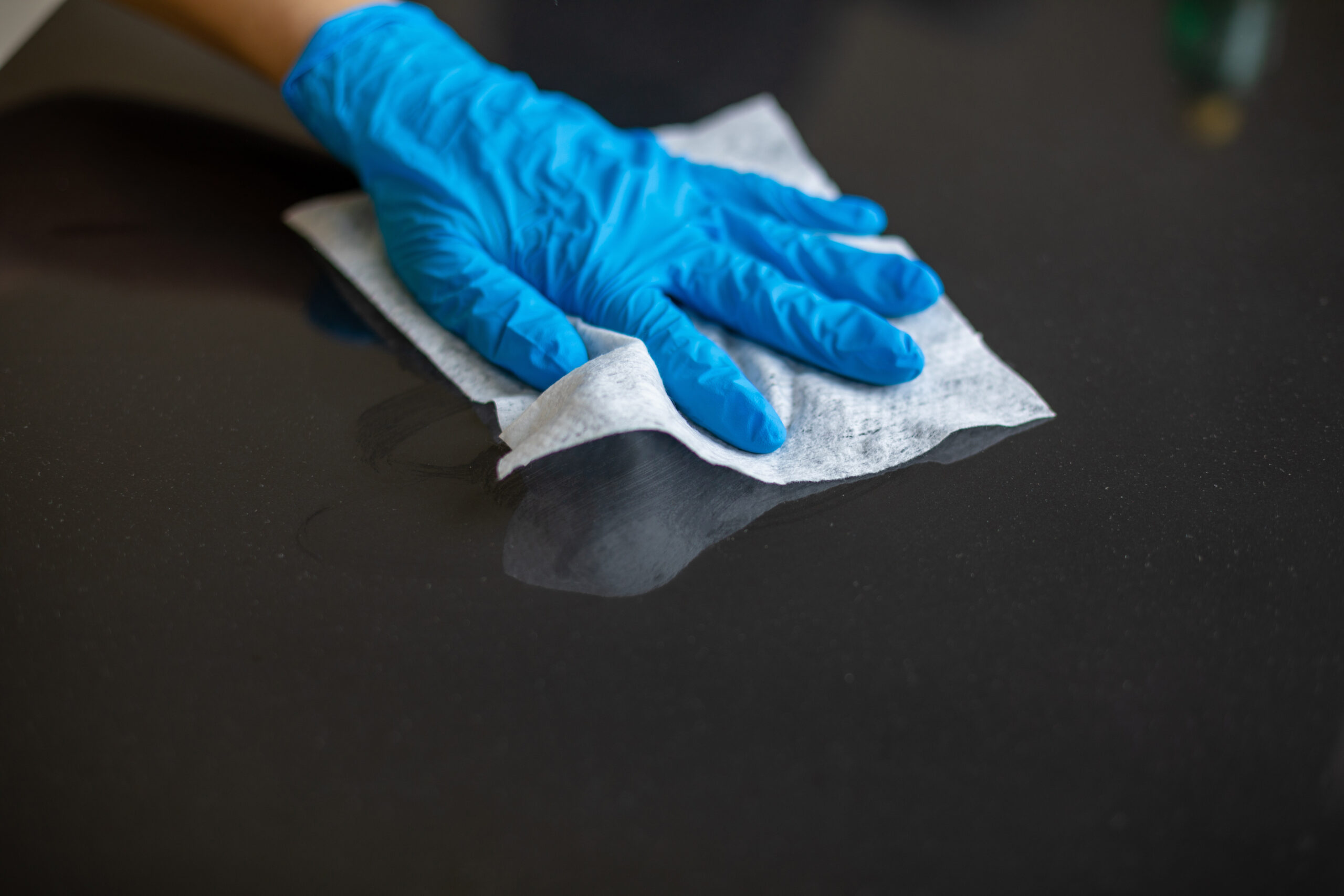 Someone cleaning a black surface with a cloth